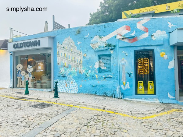 Blue mural wall art along a cobblestone street in Taipa Village, Macau China