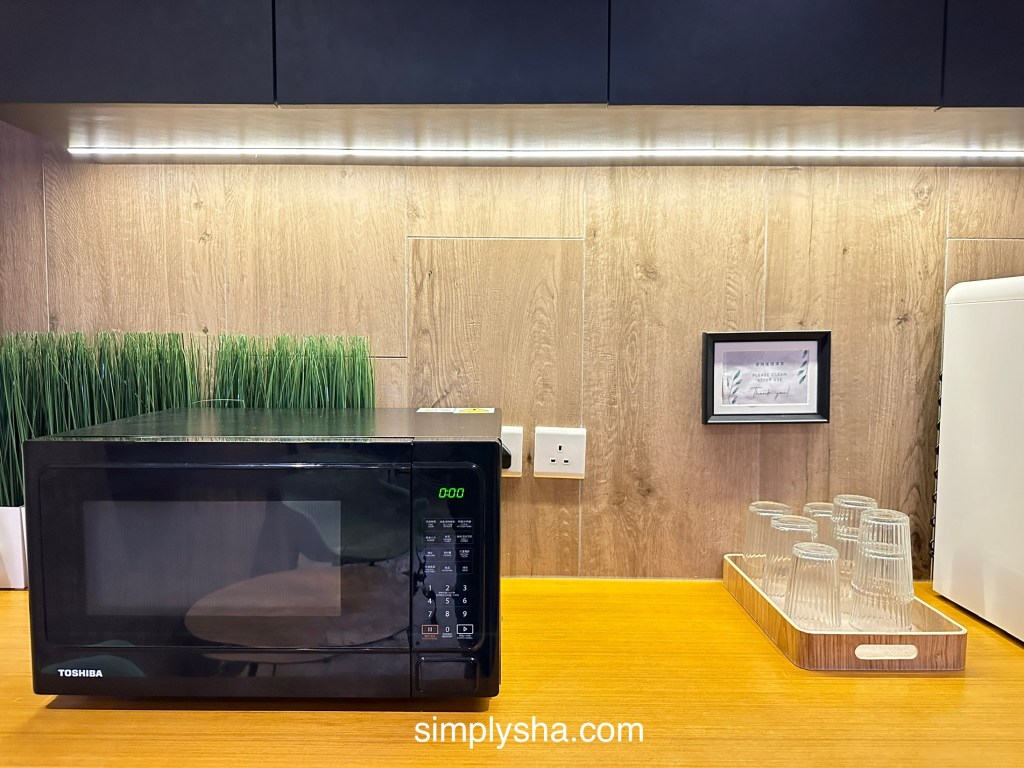 Shared microwave and drinking glasses in the common area of Belive & More Hotel, a budget-friendly choice for travelers searching where to stay in Macau.