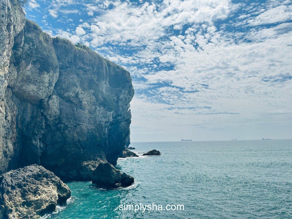 Big coastal rocks by the beach showing clouds