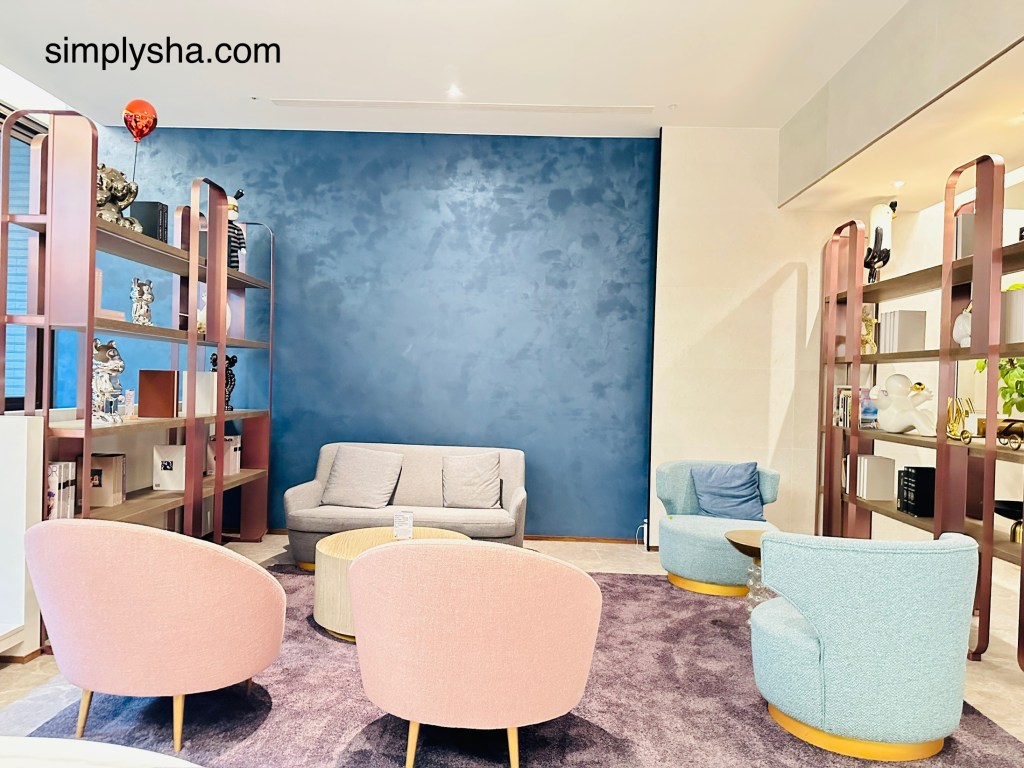 Lounge area with pink, light green and gray sofas with book shelves
