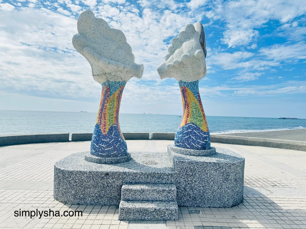 Two structures with lips pouting toward each other with the beach view
