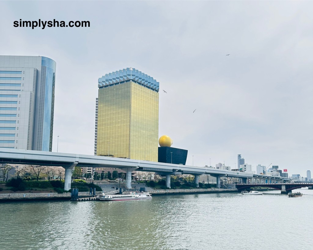 View of the Asahi Beer Hall with the famous golden flame sculpture from the Sumida River in Asakusa
