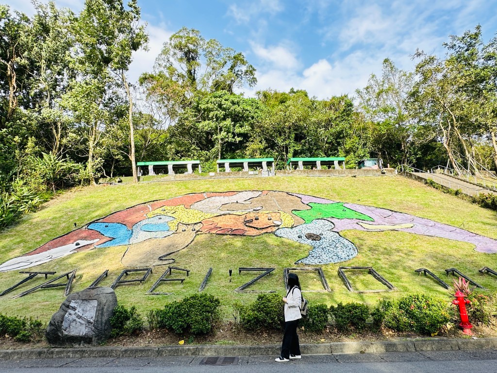 Colorful hillside artwork in Taipei Zoo surrounded by greenery on a sunny day