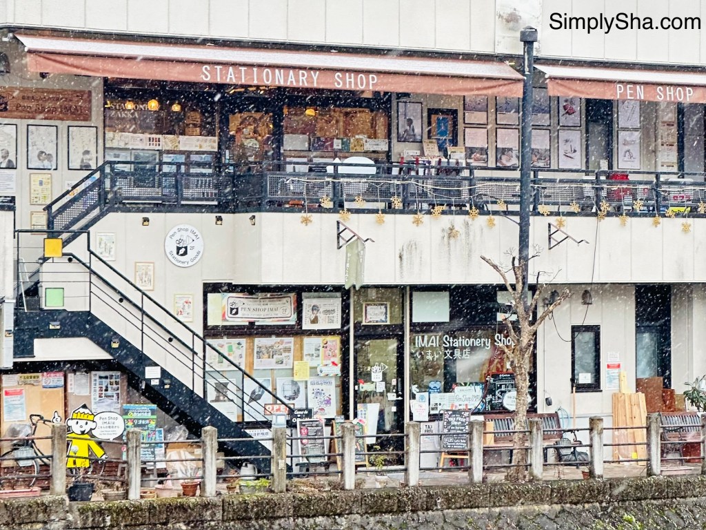 Multi-level shop houses and cafes along a snowy street in Takayama