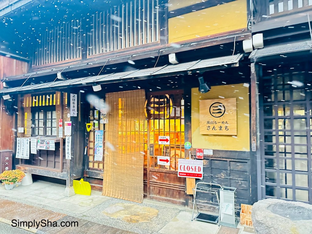 Historic wooden storefront along Sanmachi Suji Old Street in Takayama with falling snow
