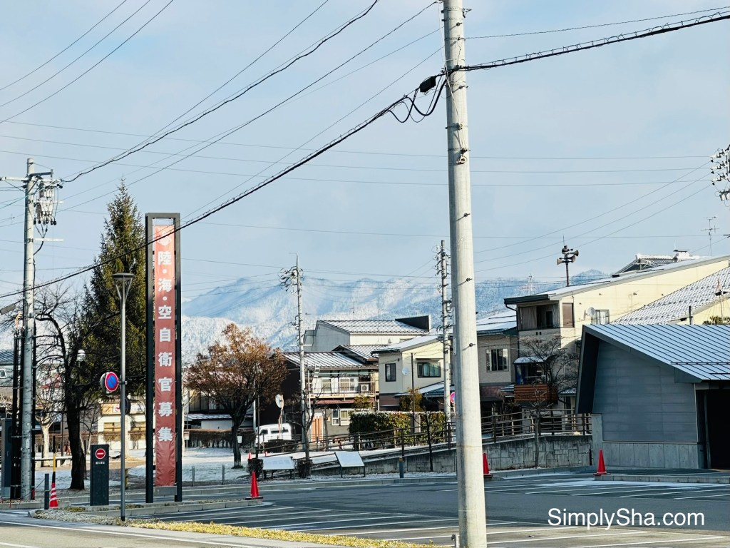 Quiet street in Takayama with snow-capped mountains in the background during winter
