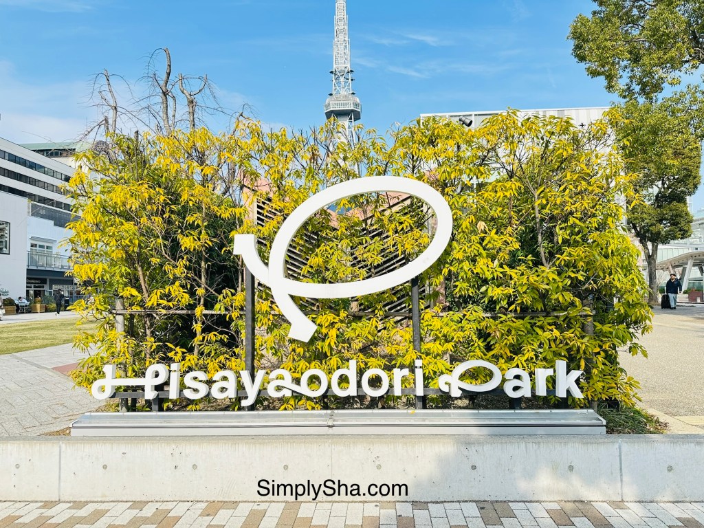 Hisaya Odori Park sign with greenery and Nagoya TV Tower in the background