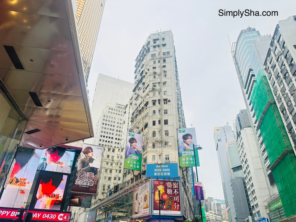 Street view of Causeway Bay, Hong Kong, featuring tall buildings, colorful advertisements, and shopping areas.