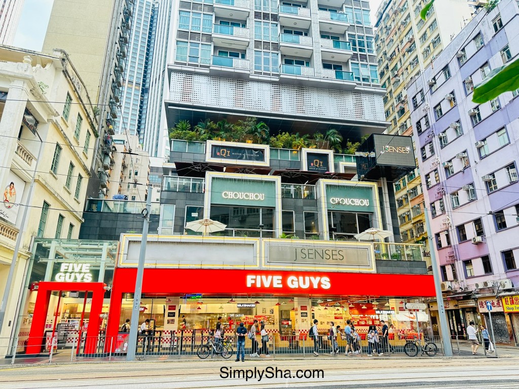 Exterior of Five Guys restaurant surrounded by high-rise buildings in Wan Chai, Hong Kong.