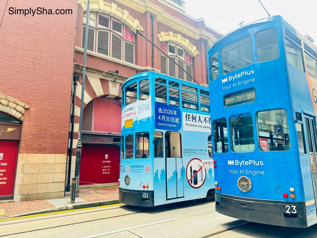 Two blue double-decker Ding Ding Trams passing each other on Hong Kong Island.
