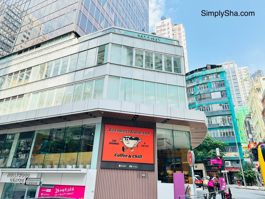 Modern glass-fronted buildings and a Coffee & Chill café along a street in Sheung Wan, Hong Kong.